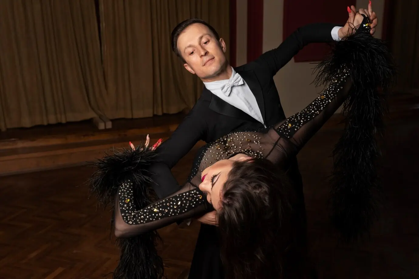 Мужчина и женщина вместе демонстрируют бальный танец.